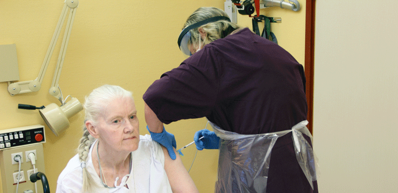 Marianne Jönsson på Korsvångsgårdens äldreboende får första dosen av kommunsjuksköterskan Marie Frimodig. 